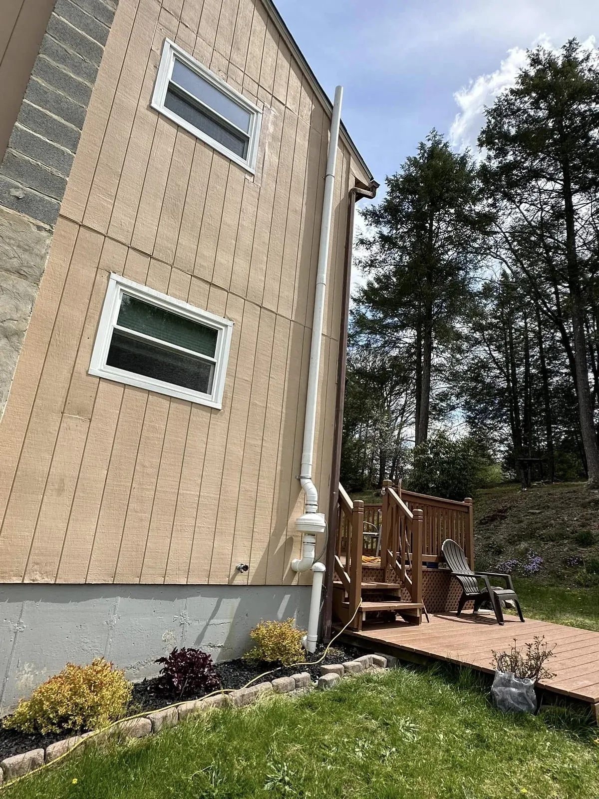 Exterior radon mitigation pipe and fan routed along a tan York County home